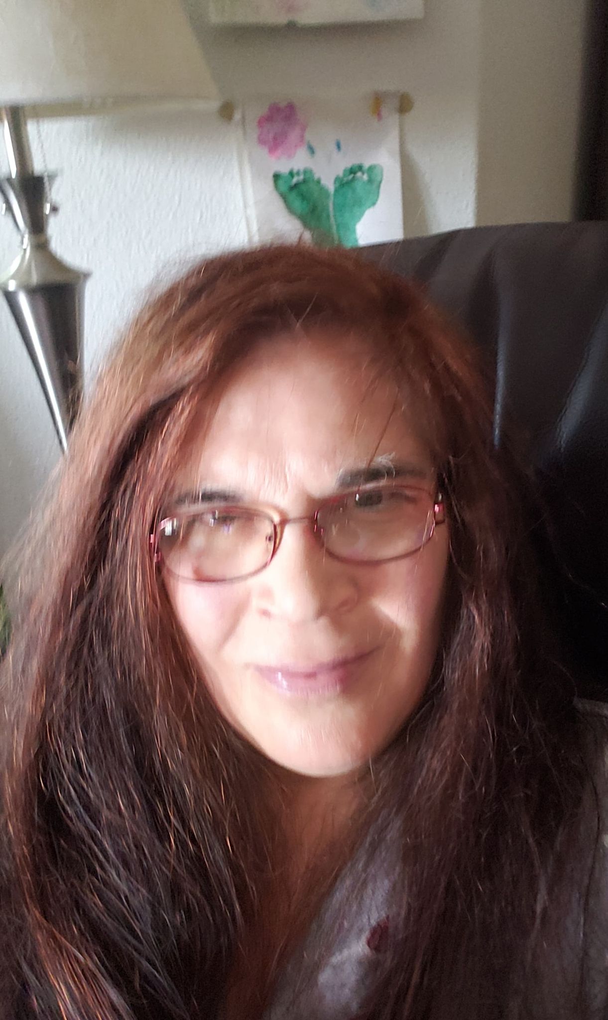A photo of a woman with long brown hair and glasses