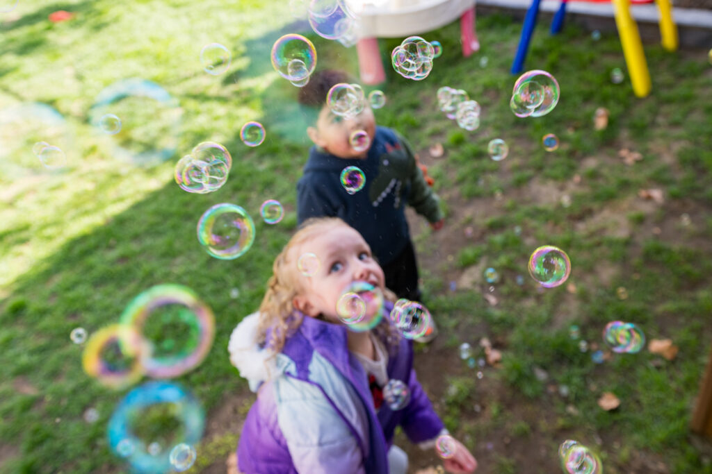 Amparo’s child care plays with bubbles outside.